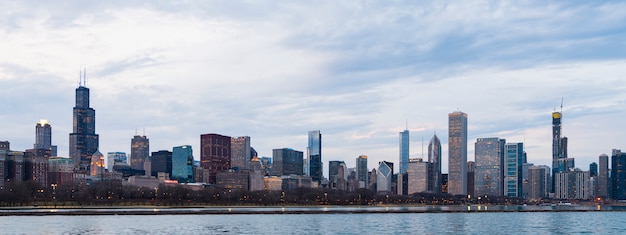 Foto hermosa vista panorámica del distrito financiero del horizonte de chicago en la noche al atardecer nublado cielo azul puesta de sol. vista panorámica a través del lago michigan y la costa de la ciudad. famosa atracción en chicago, estados unidos.