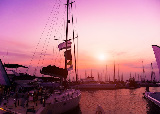 Hermosa vista del puerto deportivo y puerto con yates y lanchas. Atardecer en el océano.