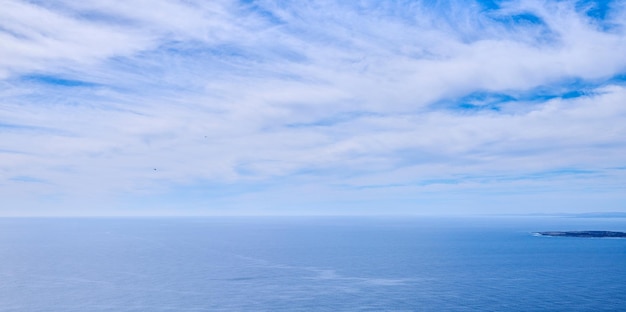 Hermosa vista tranquila y silenciosa del océano y las nubes en el cielo azul con una pequeña isla tropical y un fondo de espacio de copia Paisaje de una atmósfera nublada y clima en un entorno oceánico natural