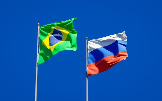 Hermosas banderas del estado nacional de Brasil y Rusia juntos en el cielo azul. Ilustraciones 3D