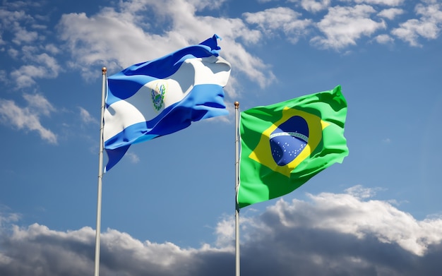 Hermosas banderas del estado nacional de Brasil y El Salvador juntos en el cielo azul