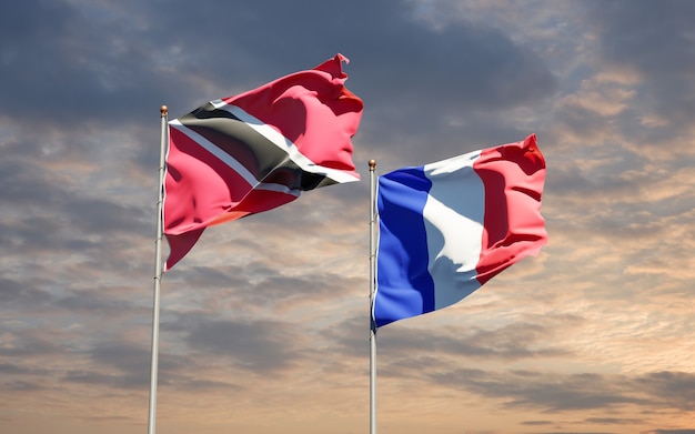 Foto hermosas banderas del estado nacional de francia y trinidad y tobago juntos en el cielo