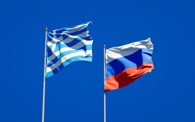 Hermosas banderas del estado nacional de Grecia y Rusia juntos en el cielo azul. Ilustraciones 3D