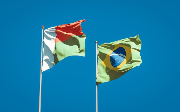 Hermosas banderas del estado nacional de Madagascar y Brasil juntos en el cielo azul