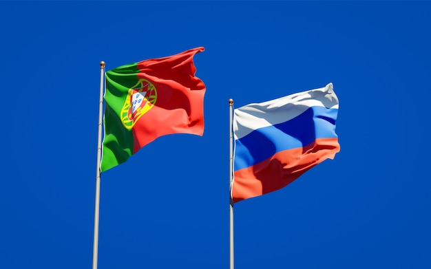Hermosas banderas del estado nacional de Portugal y Rusia juntos en el cielo azul. Ilustraciones 3D