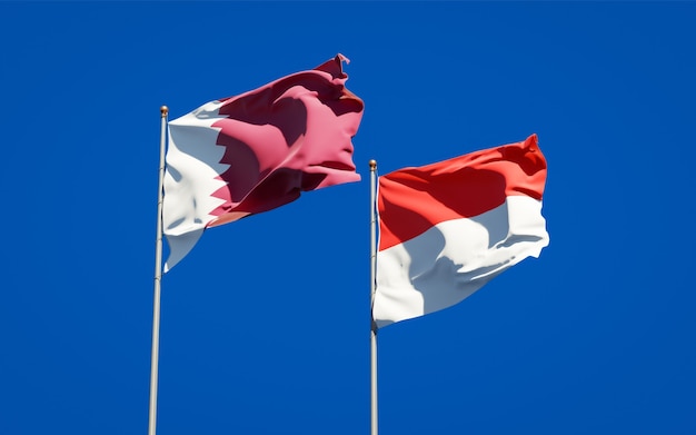 Hermosas banderas del estado nacional de Qatar e Indonesia juntos en el cielo azul