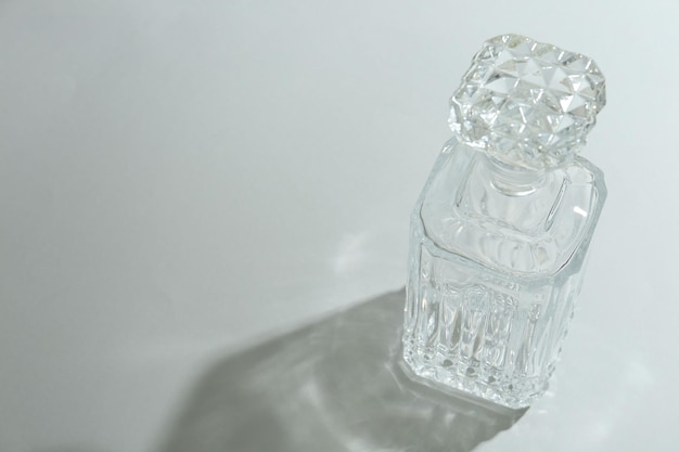 Hermosas botellas de cristal que proyectan sombras sobre un fondo claro Espacio para el texto