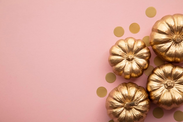 Hermosas calabazas doradas en composición de acción de gracias plana rosa pastel