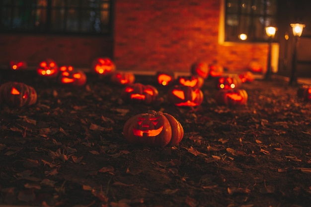 Hermosas calabazas talladas con cara graciosa naranja brillante y sonriente para las vacaciones de Halloween en la noche al aire libre