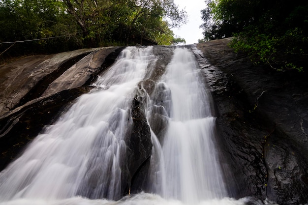 Foto hermosas cataratas de agua que fluyen hacia la roca