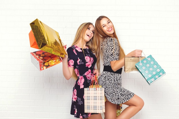 Hermosas chicas adolescentes llevando bolsas de compras