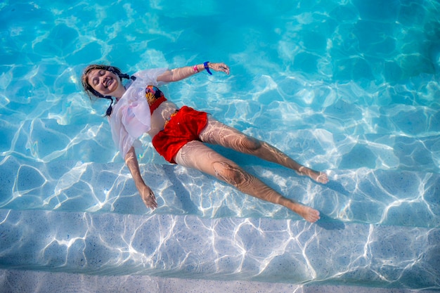 Hermosas chicas asiáticas flotan en la piscina en un caluroso día de verano