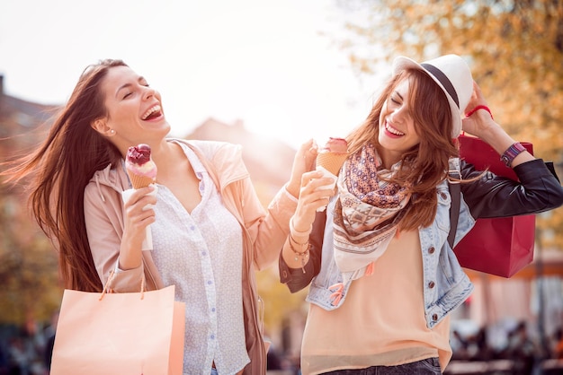 Hermosas chicas con bolsas de compras en la ciudad