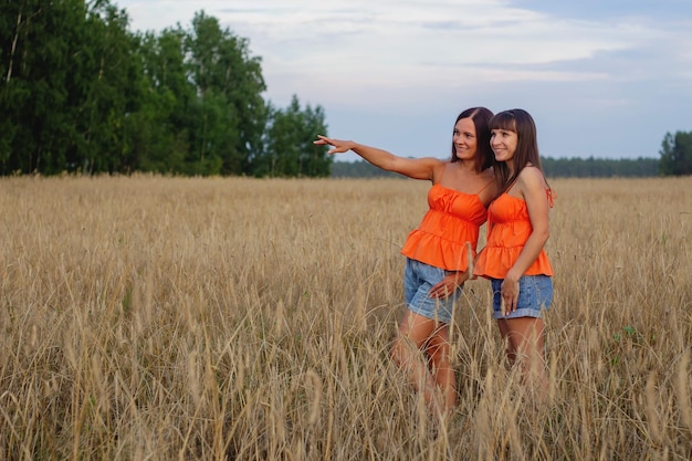 Foto hermosas chicas en un campo con trigo leche y pan tiempo de paz felicidad amor dos hermanas novias