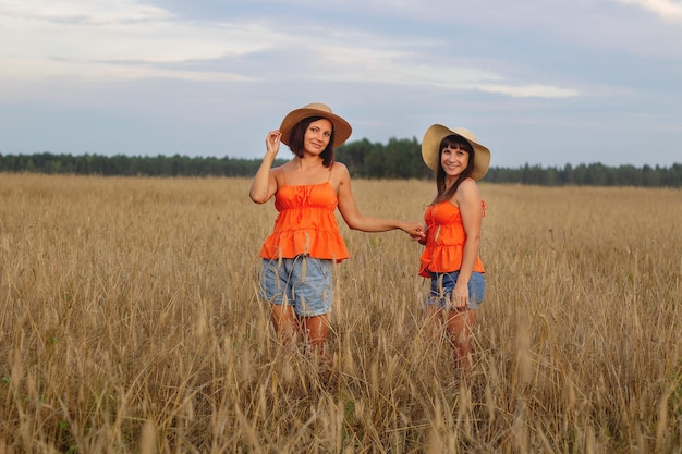 Foto hermosas chicas en un campo con trigo leche y pan tiempo de paz felicidad amor dos hermanas novias