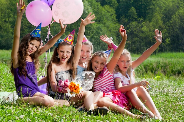 Hermosas chicas celebran cumpleaños en el parque de verano al aire libre