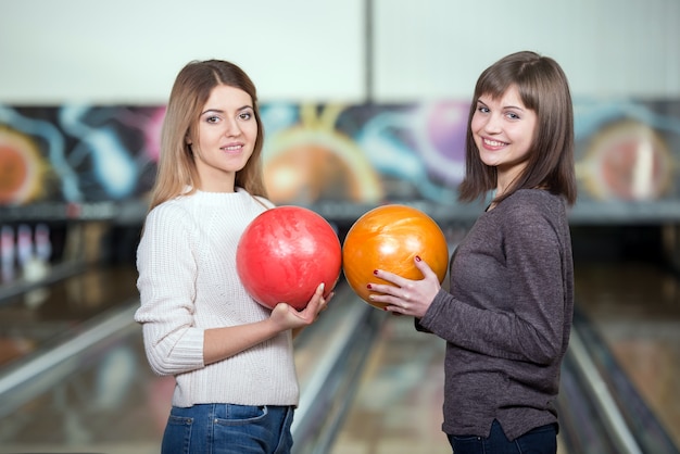 Hermosas chicas en el club de bolos tienen bolas.