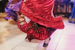 Foto hermosas chicas gitanas bailando con el tradicional vestido floral rojo en la recepción de la boda en el restaurante mujer interpretando danza romaní y canciones folclóricas en ropa nacional festival gitano de roma