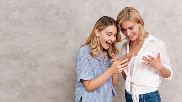 Foto hermosas chicas jóvenes revisando un mensaje