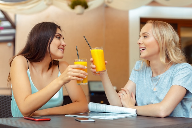 hermosas chicas jóvenes sentados a la mesa en la cafetería