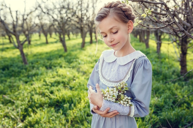 Hermosas chicas lindas en el jardín disfrutando de la llegada de vestidos de primavera en estilo vintage