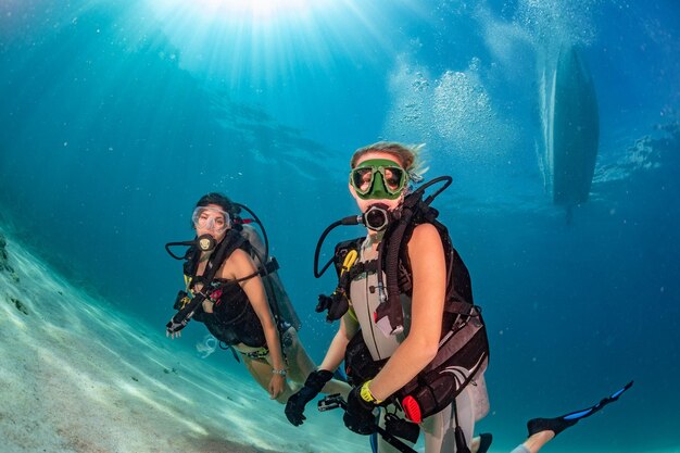 Hermosas chicas mirándote mientras nadas bajo el agua