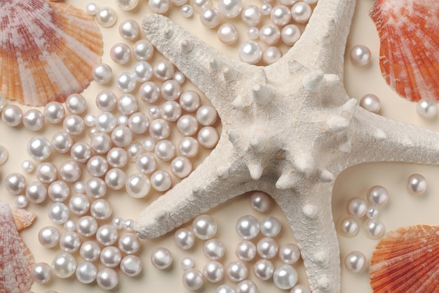 Foto hermosas conchas de mar, estrellas de mar y perlas sobre fondo beige, endecha plana