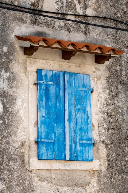 Hermosas contraventanas de madera viejas y envejecidas cerradas en la casa de piedra en la pequeña ciudad de Brsec