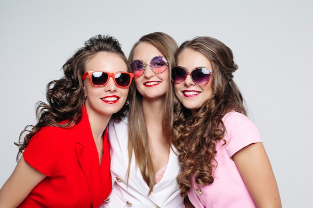 Hermosas damas felices en gafas de sol de moda y chaquetas.