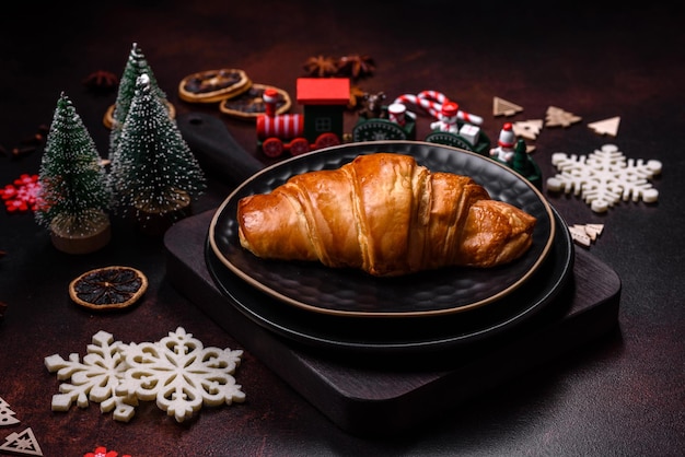 Hermosas decoraciones navideñas diferentes y croissant en una mesa de hormigón marrón