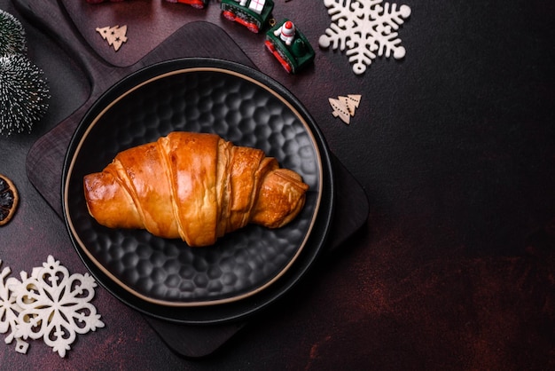 Hermosas decoraciones navideñas diferentes y croissant en una mesa de hormigón marrón