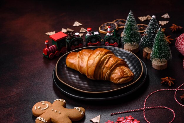 Hermosas decoraciones navideñas diferentes y croissant en una mesa de hormigón marrón