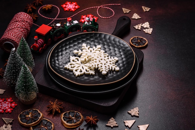 Hermosas decoraciones navideñas diferentes y pan de jengibre en una mesa de hormigón marrón