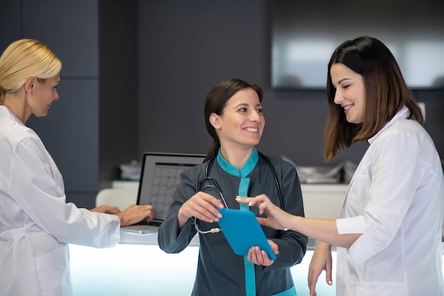 Hermosas doctoras sonriendo mientras ve videos en tableta