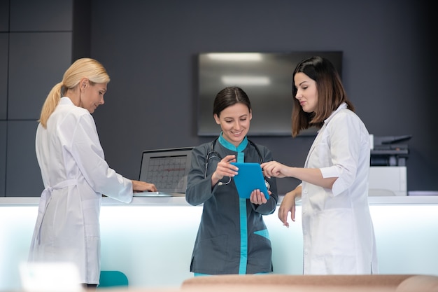 Hermosas doctoras viendo algo en línea con interés