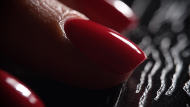 Hermosas y elegantes uñas rojas sobre fondo oscuro