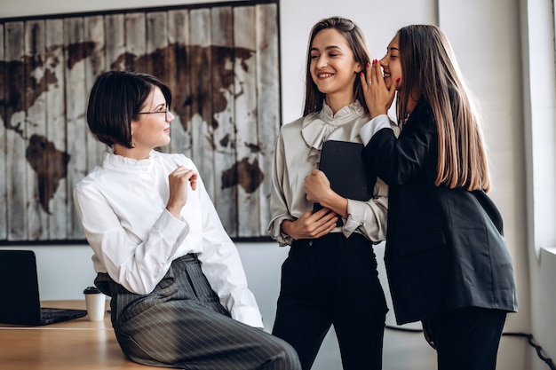 Foto hermosas empresarias discuten y susurran entre sí