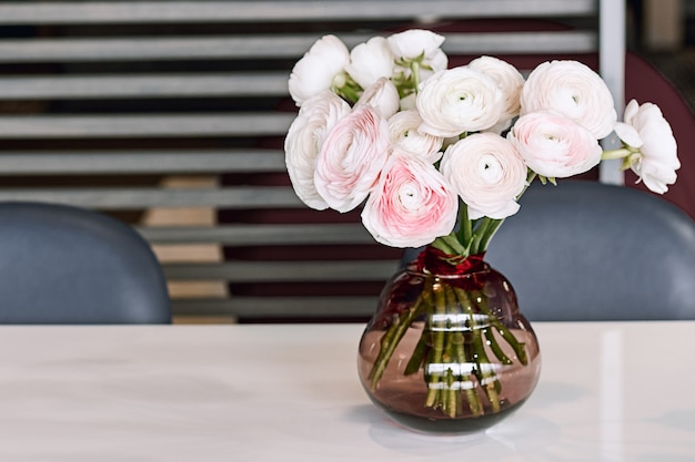 Foto hermosas flores en florero de vidrio. hermoso ramo de ranúnculo persa rosa.