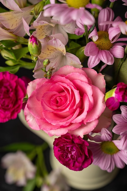 Foto hermosas flores frescas de primavera ramo rosa de flores en jarrón sobre fondo rosa