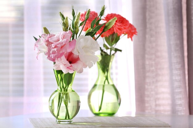 Hermosas flores en jarrón con luz de ventana