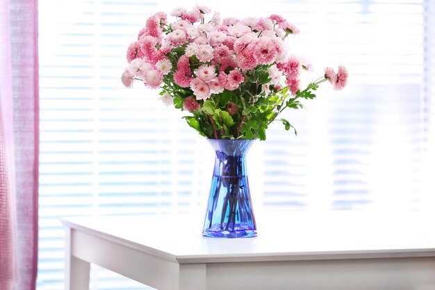 Hermosas flores en jarrón con luz de ventana