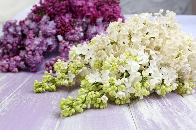 Hermosas flores lilas en mesa de madera