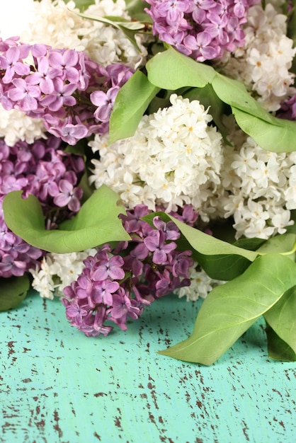 Foto hermosas flores lilas sobre fondo de madera de color