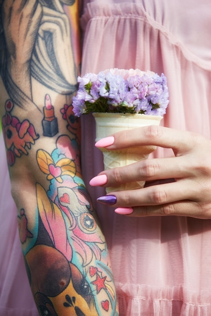 Hermosas flores en manos de una niña con tatuajes