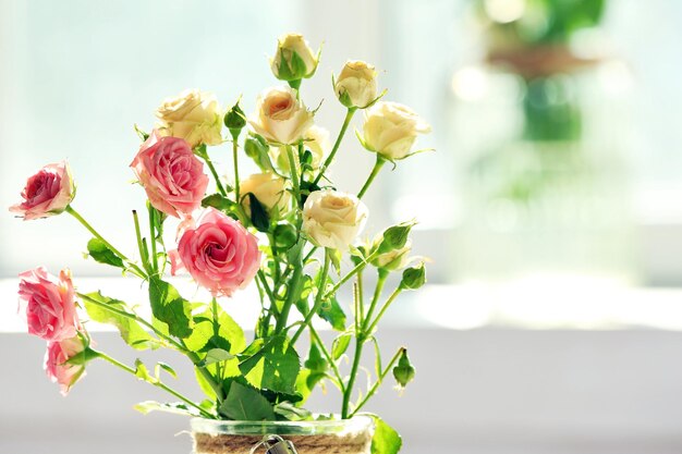 Hermosas flores de primavera en florero sobre fondo de ventana