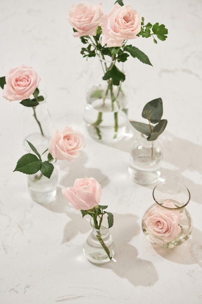 Hermosas flores rosas en jarrón sobre fondo rosa Tarjeta de felicitación para el día de la mujer o el día de la madre