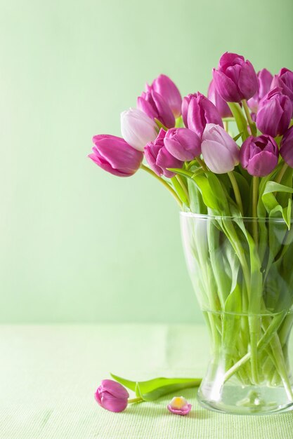 Hermosas flores de tulipán púrpura en florero