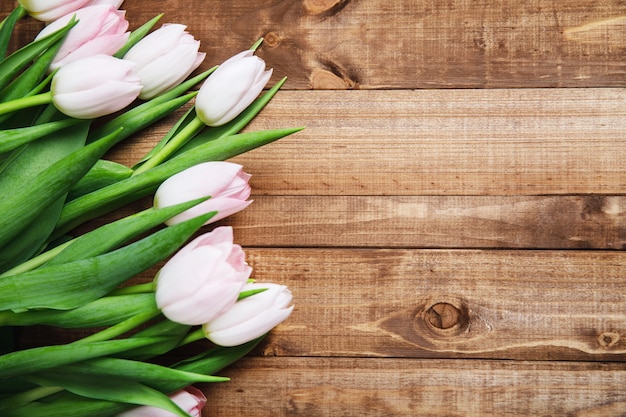 Hermosas flores de tulipán rosa en la tabla de madera