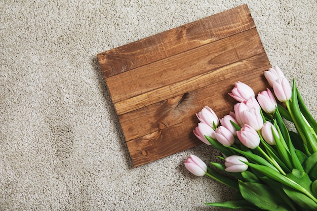 Hermosas flores de tulipán rosa en la tabla de madera