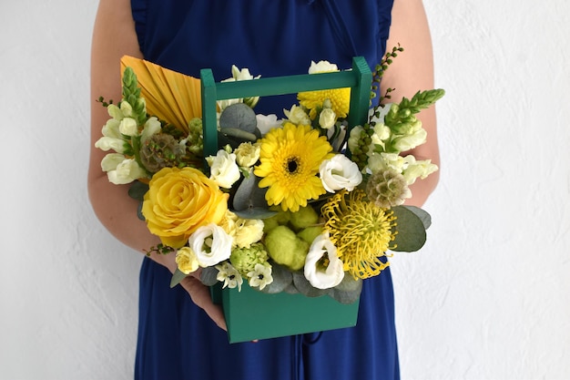 Hermosas flores para vacaciones Mujer con hermosas flores en las manos en el interior de fondo ramo de flores para floristería